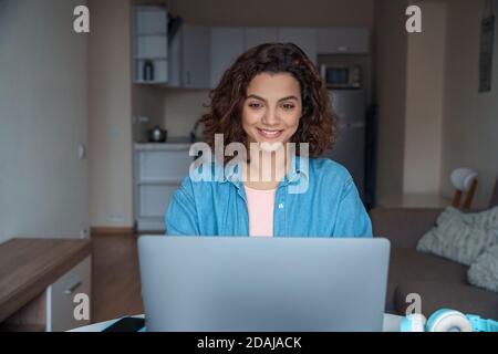 Jeune femme latine souriante freelance travaillant en ligne sur ordinateur portable. Banque D'Images