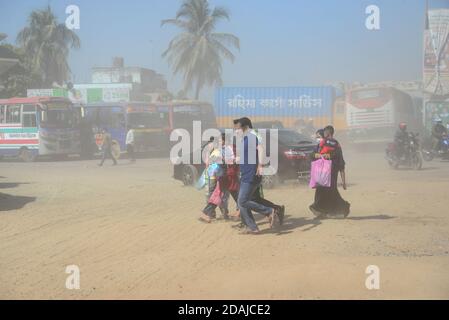 Les gens marchent sur une route poussiéreuse très fréquentée à Dhaka, au Bangladesh, le 12 novembre 2020. L'état de l'air de la ville de Dhaka s'aggrave jour après jour en cas d'alarme Banque D'Images