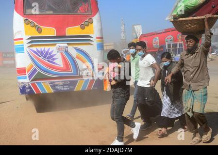 Les gens marchent sur une route poussiéreuse très fréquentée à Dhaka, au Bangladesh, le 12 novembre 2020. L'état de l'air de la ville de Dhaka s'aggrave jour après jour en cas d'alarme Banque D'Images