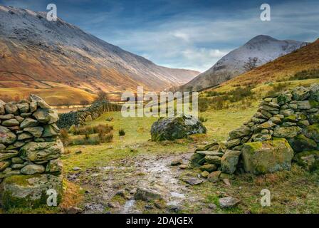 Une vue de la vallée de Hartsop à travers un mur de pierre sèche qui s'écroule en regardant vers les sommets enneigés de Hartsop Dodd , caudale Moor et Middle Dodd i Banque D'Images