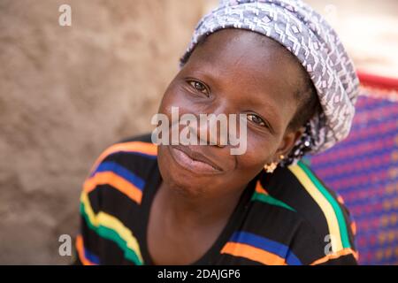 Village de Tanga, région de Selingue, Mali, 27 avril 2015 ; Mamadou Camara, 42, est un agriculteur. En tant que garçon de 12 ans, il vivait avec sa famille à Tangakoro, près de la rivière avant la construction du barrage. Ils ont été forcés de déménager dans le village de Tanga à cause du barrage. Il aimerait cultiver des légumes mais le sol est trop dur et rocailleux. Kadiatou Traure, sa femme, avec leur premier enfant. Elle attend bientôt un deuxième enfant. Banque D'Images