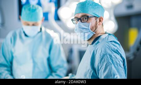 Portrait prise d'un chirurgien regardant dans l'appareil photo. Équipe diversifiée de chirurgiens professionnels, d'assistants et d'infirmières effectuant une chirurgie invasive sur un patient Banque D'Images