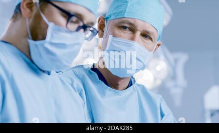 Dans la salle d'opération deux chirurgiens pendant la procédure chirurgicale. Médecins professionnels de l'hôpital moderne. Banque D'Images