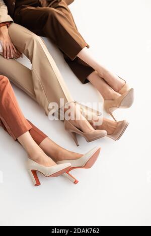 vue en hauteur des femmes dans les pantalons tendance et les hauts chaussures au talon sur blanc Banque D'Images