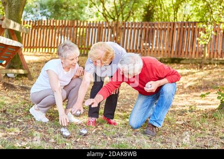 Les aînés jouant des boules dans le jardin discutent de la distance entre les boules Banque D'Images