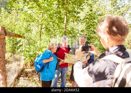 Femme prend une photo de la randonnée de groupe senior avec un smartphone Banque D'Images