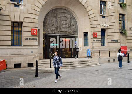 Un étudiant portant un masque facial protecteur passe devant le LSE Old Building de la London School of Economics. Alors que la plupart des magasins et des entreprises ont dû fermer pendant le deuxième confinement national en Angleterre, les universités et les écoles sont autorisées à rester ouvertes. Banque D'Images