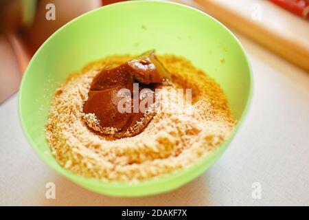 Mélange des ingrédients pour la tarte. Lait concentré bouilli avec biscuits moulés. La base du gâteau. Préparation de biscuits. Fond de cuisson. Banque D'Images