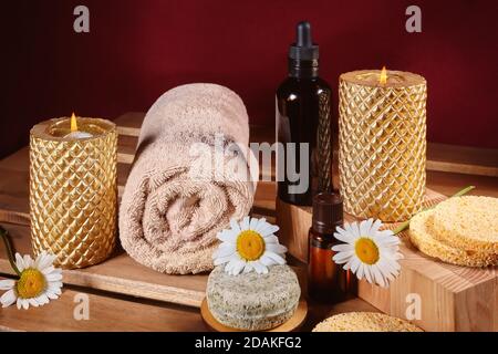 Magnifique composition du spa. Aromathérapie à l'huile de fines herbes, savon naturel et bougies dorées. Couleurs relaxants et serviettes réchauffant sur fond en bois Banque D'Images