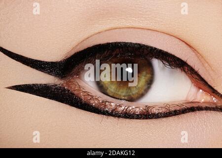 Superbe photo macro de l'œil féminin avec maquillage eyeliner classique. Forme parfaite des sourcils, des fards à paupières bruns et des cils longs. Cosmétiques et maquillage Banque D'Images