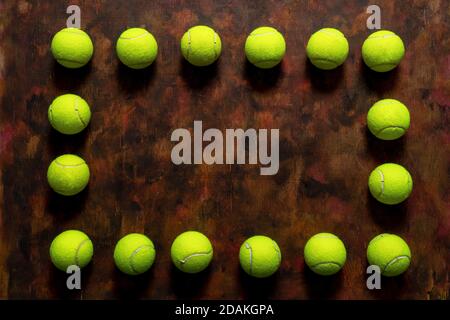 Balles de tennis en composition sur fond de bois ancien dans des tons bruns. Concept sport Banque D'Images