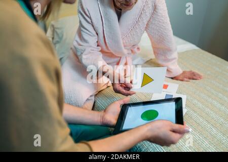 Femme médecin montrant formes géométriques pour patient âgé Banque D'Images