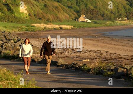 Croy Shore , Carrick, Ayrshire , Écosse, Royaume-Uni . Deux dames apprécient une promenade en fin d'après-midi le long de la côte Banque D'Images