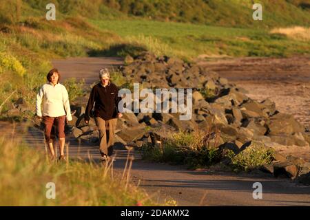 Croy Shore , Carrick, Ayrshire , Écosse, Royaume-Uni . Deux dames apprécient une promenade en fin d'après-midi le long de la côte Banque D'Images