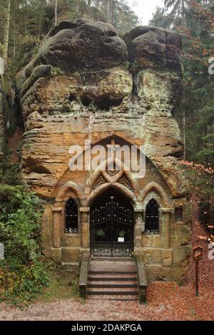 Chapelle des rochers dans la Modlivý důl (vallée de la prière) près de Svojkov dans les montagnes de Lusatien en Bohême du Nord, République tchèque. Le portail gothique de la chapelle a été sculpté par le sculpteur amateur local Antonín Wagner sculpté dans les rochers naturels en 1836. La chapelle rocheuse est consacrée à notre-Dame de Lourdes. Banque D'Images