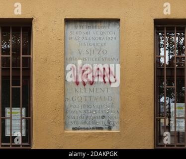 Plaque commémorative dédiée au Klement Gottwald vandalisée par l'inscription rouge sanglante 'Murderer' dans le quartier de Holešovice à Prague, République tchèque. Klement Gottwald a été le premier président communiste de la Tchécoslovaquie. Le texte en tchèque dit que Klement Gottwald a été élu dans cette maison pour être un chef du Parti communiste de Tchécoslovaquie en février 1929. La plaque commémorative de la rue Na Maninách est le dernier exemple de propagande monumentale communiste à Prague qui survit encore après l'effondrement du régime communiste en 1989. L'inscription rouge et sanglante 'Surderer' ('Vrah' en tchèque Banque D'Images