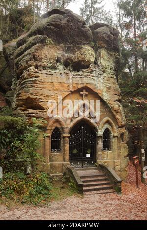 Chapelle des rochers dans la Modlivý důl (vallée de la prière) près de Svojkov dans les montagnes de Lusatien en Bohême du Nord, République tchèque. Le portail gothique de la chapelle a été sculpté par le sculpteur amateur local Antonín Wagner sculpté dans les rochers naturels en 1836. La chapelle rocheuse est consacrée à notre-Dame de Lourdes. Banque D'Images