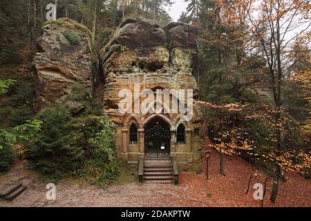 Chapelle des rochers dans la Modlivý důl (vallée de la prière) près de Svojkov dans les montagnes de Lusatien en Bohême du Nord, République tchèque. Le portail gothique de la chapelle a été sculpté par le sculpteur amateur local Antonín Wagner sculpté dans les rochers naturels en 1836. La chapelle rocheuse est consacrée à notre-Dame de Lourdes. Banque D'Images