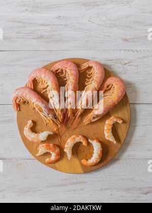 Crevettes géantes fraîches cuites sur une planche à découper en bois. Vue de dessus. Banque D'Images