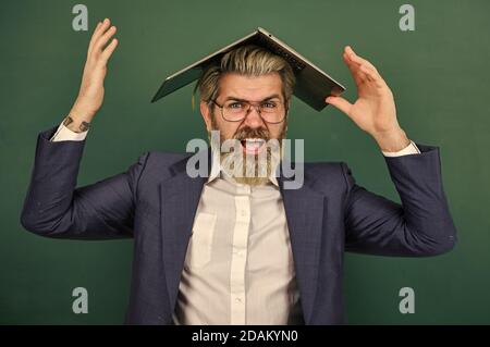 Homeschooling. Folie en ligne. Fournir des informations précises à jour. L'enseignant tient un ordinateur portable surfer sur Internet. Homme barbu portable sur la tête. Informations intéressantes. Sauvetage scolaire. Beaucoup d'informations. Banque D'Images