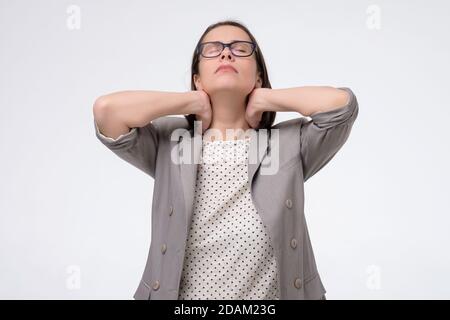 Femme d'affaires mûre massant son cou douloureux se reposant après le travail Banque D'Images
