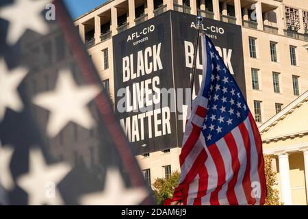 Washington, États-Unis. 13 novembre 2020. Les drapeaux américains sont brandis au BLM Plaza, alors qu'un grand panneau Black Lives Matter est accroché en arrière-plan en tant que partisans du président américain Donald Trump et de ceux qui s'opposent à l'affrontement de Trump au BLM Plaza près de la Maison Blanche à Washington, DC, le vendredi 13 novembre 2020. Les partisans de Trump prétendent qu'il est toujours le vainqueur et qu'il continuera pendant encore 4 ans. Photo de Ken Cedeno/UPI. Crédit : UPI/Alay Live News Banque D'Images