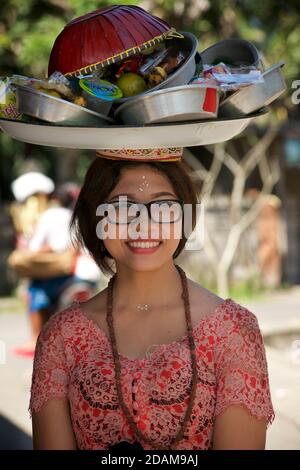 Femme balinaise exécutant une mapeedÊÐ procession Ð au temple, portant des offrandes sur sa tête pour le temple de Sakenan Galungan, Bali, Indonésie. Banque D'Images