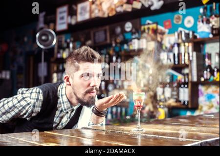 Un barbeller professionnel verse une boisson au comptoir du bar Banque D'Images