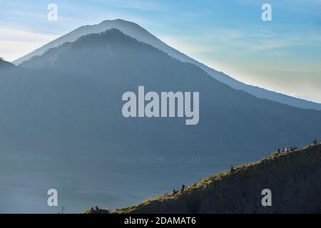 Randonneurs se rassemblant sur le bord de la caldeira du mont Batur pour le lever du soleil, Bali, Indonésie. Banque D'Images