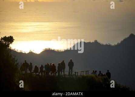 Randonneurs se rassemblant sur le bord de la caldeira du mont Batur pour le lever du soleil, Bali, Indonésie. Banque D'Images