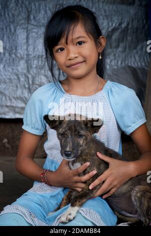 Portrait d'une fille indonésienne avec son chiot. Bali, Indonésie Banque D'Images