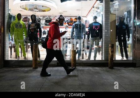 Newark, New Jersey, États-Unis. 13 novembre 2020. Une personne passe devant un magasin sur Broad Street à Newark, dans le New Jersey. Le maire Ras J. Baraka a annoncé que l'Administration prend des mesures supplémentaires pour enrayer la propagation du coronavirus. La COVID-19 est toujours en hausse à Newark, la ville ayant signalé 12,779 cas positifs et 677 décès en novembre 9. Le 27 octobre 2020, la ville de Newark a promulgué à 20h Curhew Credit: Brian Branch Price/ZUMA Wire/Alamy Live News Banque D'Images