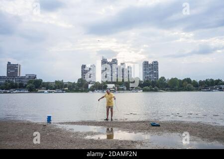 BELGRADE, SERBIE - 15 JUILLET 2017 : vieil homme, pêcheur avec filets de pêche, debout en face du danube à Zemun, sur la plage du lido sur le Véliko Ra Banque D'Images