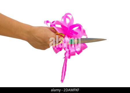 mans main de couper quelque chose avec des ciseaux et noeud rose isolé sur fond blanc. Banque D'Images
