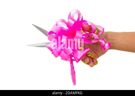 mans main de couper quelque chose avec des ciseaux et noeud rose isolé sur fond blanc. Banque D'Images