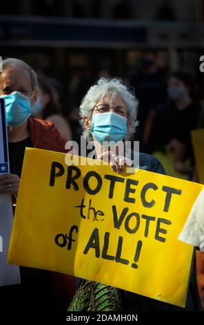 Copley Square, Boston, Massachusetts, États-Unis, 7 novembre 2020. Un certain nombre d'organisations communautaires se sont réunies pour exiger que la démocratie soit protégée et que chaque vote aux élections de 2020 soit compté. La photo montre un couple d'âge moyen tenant des affiches pendant la démonstration. Lors de la démonstration, tous ont été tenus de porter un masque ou un masque facial et, dans la mesure du possible, à distance sociale. Banque D'Images