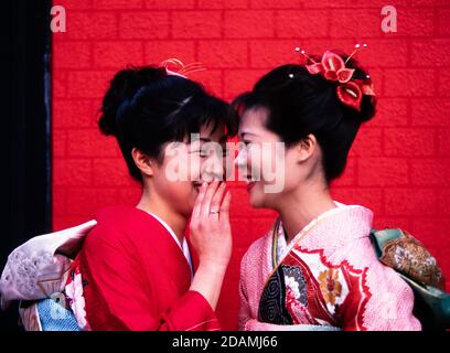 Deux femmes japonaises en kimonos de cérémonie, se rencontrent dans une rue de Tokyo, au Japon. Banque D'Images