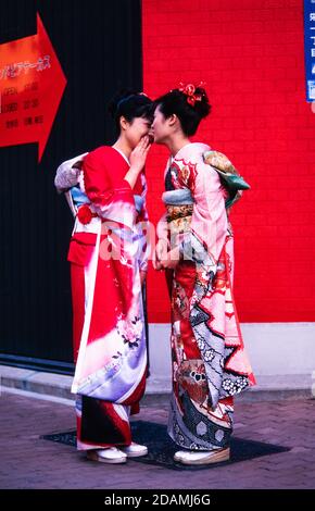 Deux femmes japonaises en kimonos de cérémonie, se rencontrent dans une rue de Tokyo, au Japon. Banque D'Images