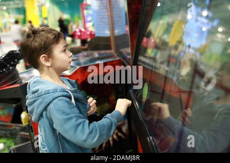 Un enfant joue sur un écran tactile dans un parc de loisirs Banque D'Images