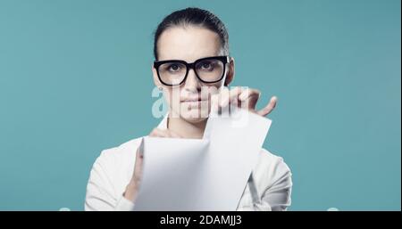 Une femme déçue de déchirer un contrat, elle est déchirer le document et regarder la caméra Banque D'Images