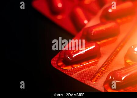 paquets de comprimés dans un emballage rouge sur fond noir. Banque D'Images