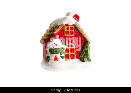 Décoration de Noël - une fabuleuse maison en céramique avec un bonhomme de neige, lumière de la fenêtre, un sapin de Noël et de la neige. Nouvelle année. Isolez-vous sur un fond blanc Banque D'Images