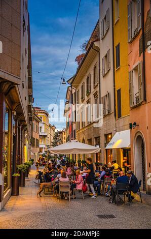 Brescia, Italie, 10 septembre 2019: Rue étroite typiquement italienne avec vieux bâtiments traditionnels et restaurant de rue avec des personnes ayant le dîner, centre historique, vue à la tombée de la nuit, Lombardie Banque D'Images