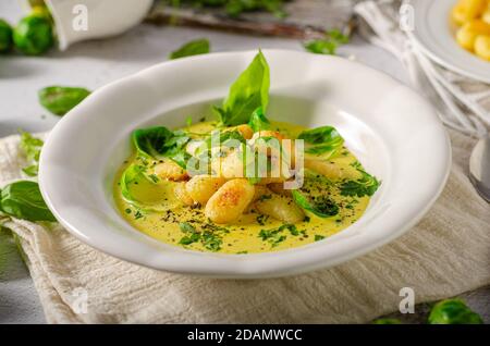 Gnocchi croustillant à la sauce au curry avec choux de bruxelles Banque D'Images