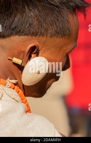 Résumé Portrait d'un tribesman naga habillé dans sa tribu Tenue de ville portant une grande boucle d'oreille blanche traditionnelle à Kisama Nagaland Inde le 4 décembre 2016 Banque D'Images