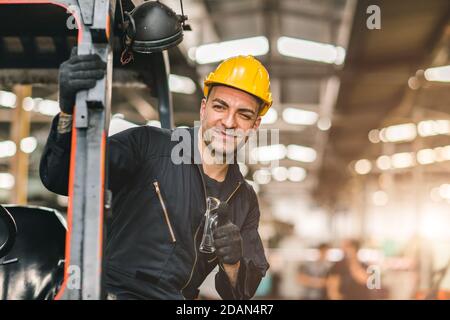 Portrait d'un travailleur caucasien souriant heureux pouce vers le haut pour un bon travail à l'usine d'expédition logistique de fret ou le lieu de travail d'entrepôt. Banque D'Images