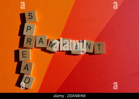 Propagation endémique, mots en lettres de l'alphabet en bois en forme de mots croisés sur fond coloré Banque D'Images