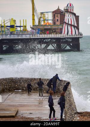 Brighton UK 14 novembre 2020 - les vagues se brisent au-dessus de Brighton front de mer Albion grin et les visiteurs se prélasser sur une journée venteuse le long de la côte sud : Credit Simon Dack / Alay Live News Banque D'Images