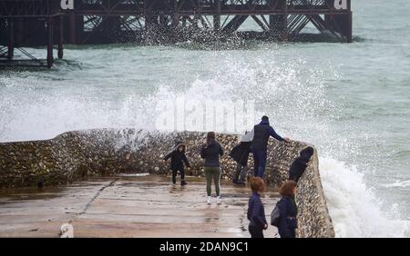 Brighton UK 14 novembre 2020 - les vagues se brisent au-dessus de Brighton front de mer Albion grin et les visiteurs se prélasser sur une journée venteuse le long de la côte sud : Credit Simon Dack / Alay Live News Banque D'Images