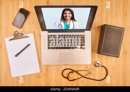 ordinateur portable sur un bureau avec chat vidéo en ligne par jeune médecin latin Banque D'Images